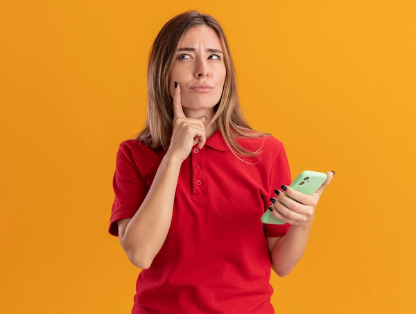 mulher em dúvida segurando telefone